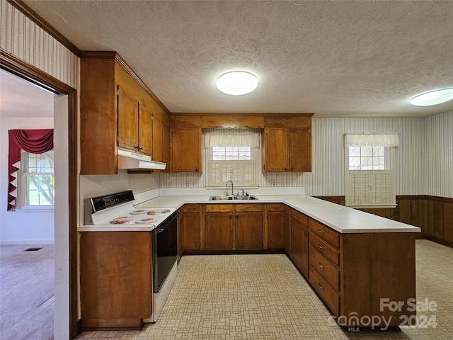 kitchen featuring white range with electric cooktop, a textured ceiling, kitchen peninsula, and sink