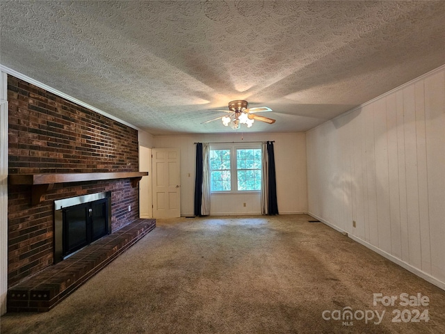 unfurnished living room with a textured ceiling, a fireplace, carpet flooring, ceiling fan, and wooden walls