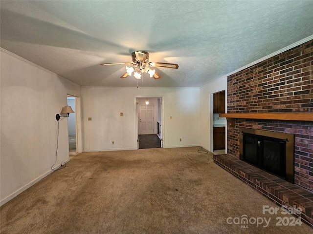 unfurnished living room with ceiling fan, a fireplace, carpet, and a textured ceiling