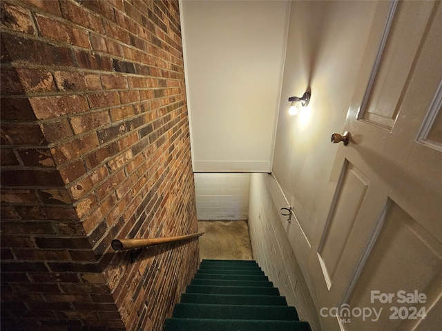 stairs featuring brick wall