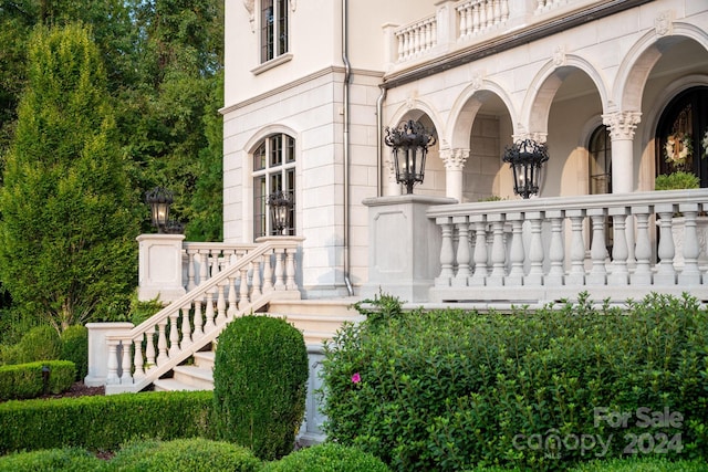 doorway to property with stone siding and a balcony