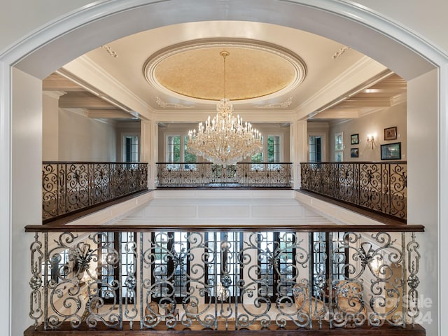 interior space featuring an inviting chandelier, crown molding, and arched walkways