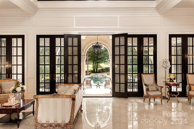 entryway with crown molding and french doors