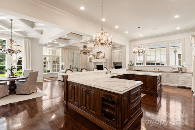 kitchen featuring beamed ceiling, a notable chandelier, coffered ceiling, a large island, and dark brown cabinets