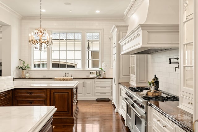 kitchen featuring dark hardwood / wood-style floors, crown molding, tasteful backsplash, and double oven range