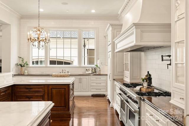 kitchen with dark wood finished floors, range with two ovens, tasteful backsplash, and a chandelier