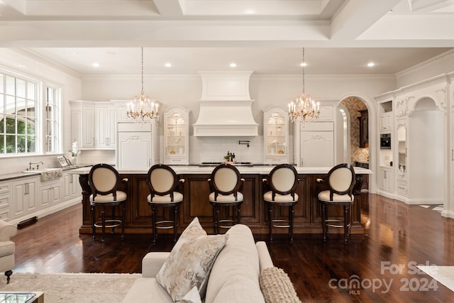 interior space with a kitchen island with sink, a kitchen bar, and decorative light fixtures