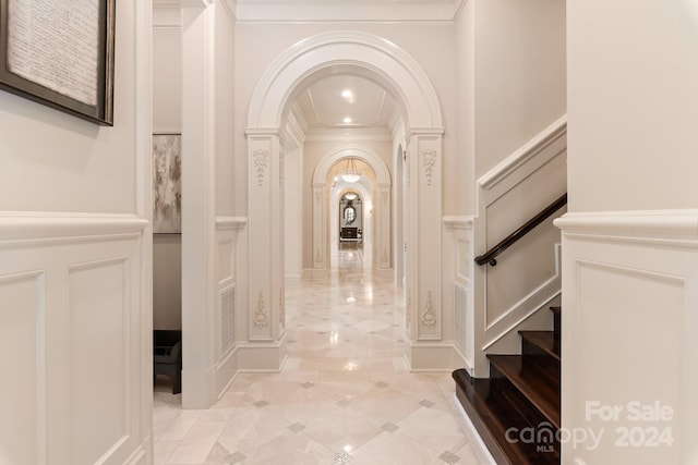 corridor with arched walkways, a decorative wall, and stairs