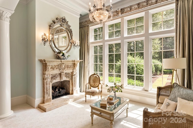 living room with ornate columns, carpet flooring, a notable chandelier, and ornamental molding