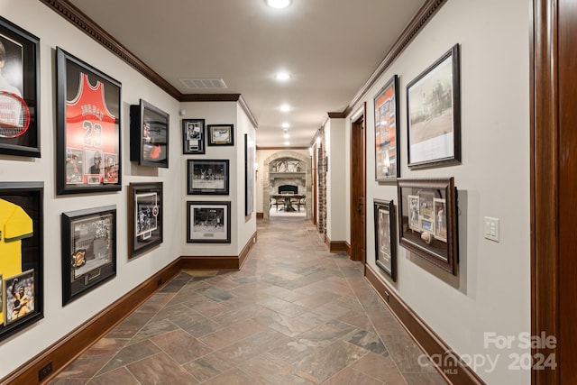 corridor featuring visible vents, stone tile flooring, recessed lighting, crown molding, and baseboards