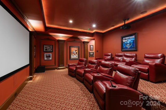 carpeted cinema room featuring crown molding, a raised ceiling, and decorative columns