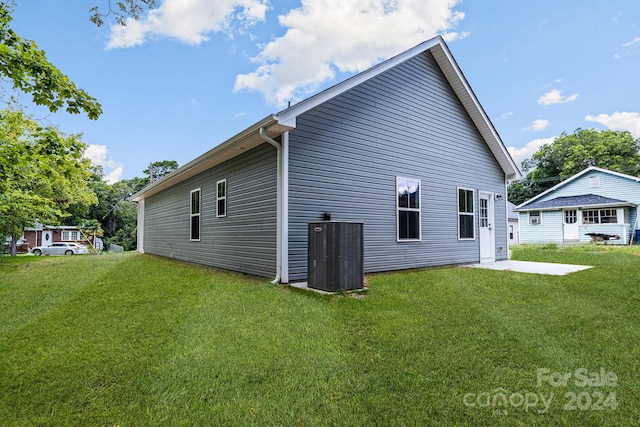 view of home's exterior with central AC unit and a lawn