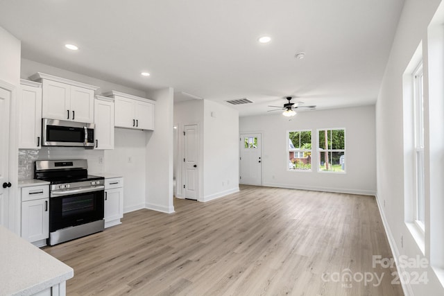 kitchen featuring light wood finished floors, white cabinetry, appliances with stainless steel finishes, and light countertops