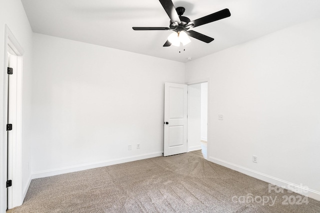 spare room featuring carpet, ceiling fan, and baseboards