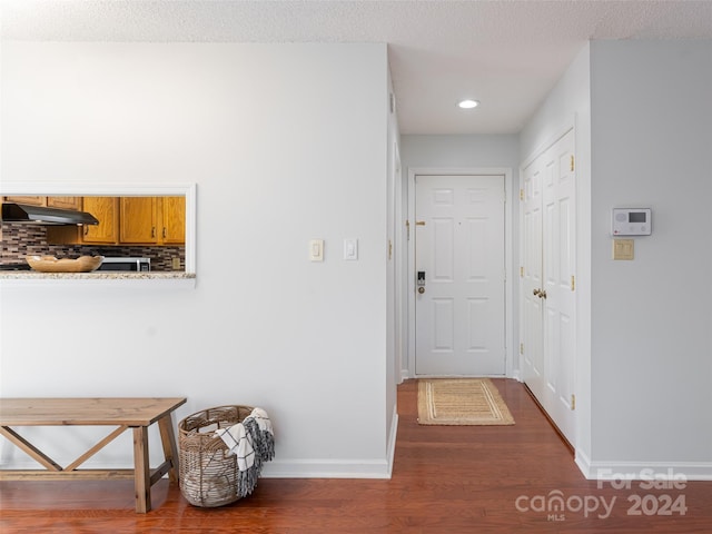 hallway featuring dark hardwood / wood-style flooring and a textured ceiling