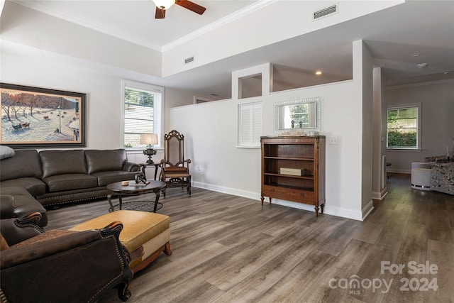 living room featuring crown molding, a healthy amount of sunlight, ceiling fan, and dark wood-type flooring