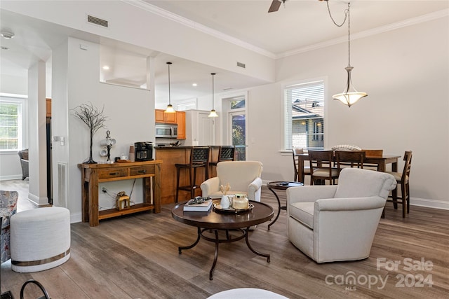 living room with plenty of natural light, ornamental molding, and hardwood / wood-style floors