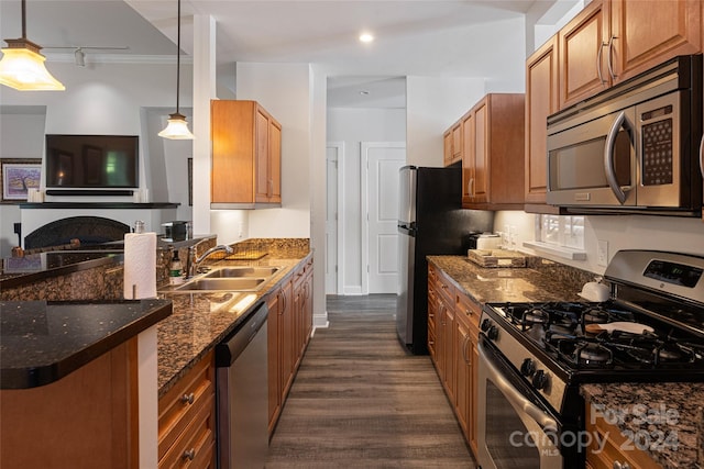 kitchen with pendant lighting, sink, appliances with stainless steel finishes, and dark wood-type flooring