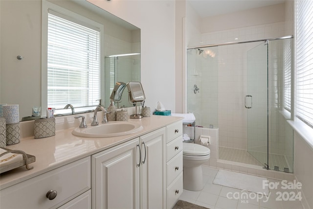bathroom with tile patterned flooring, vanity, toilet, and an enclosed shower