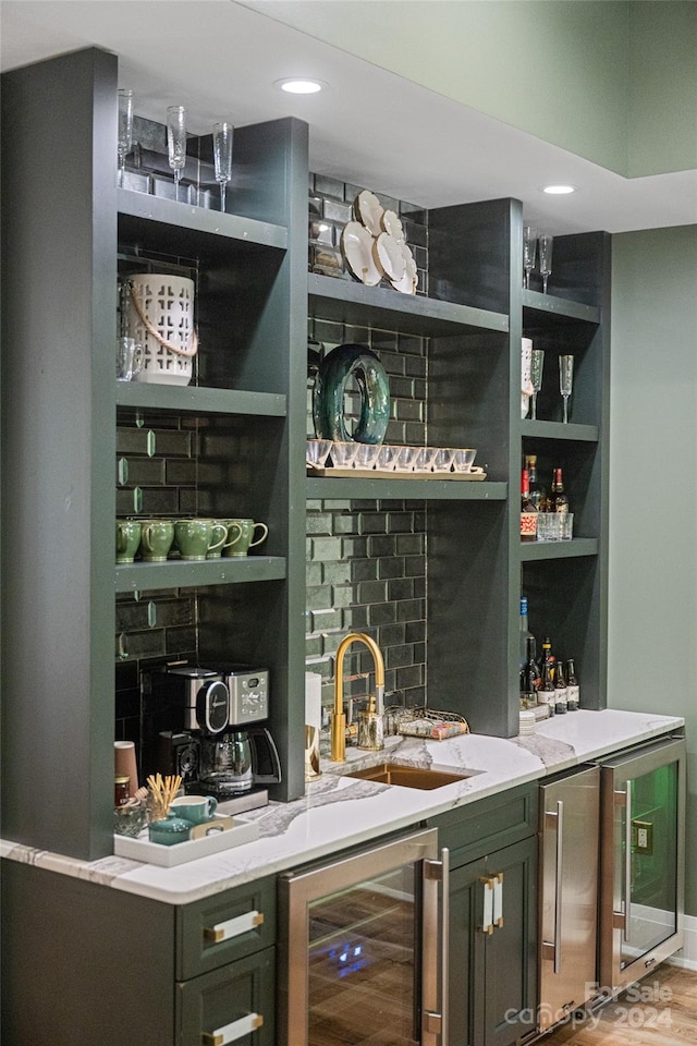 bar featuring wood-type flooring, light stone countertops, wine cooler, and sink