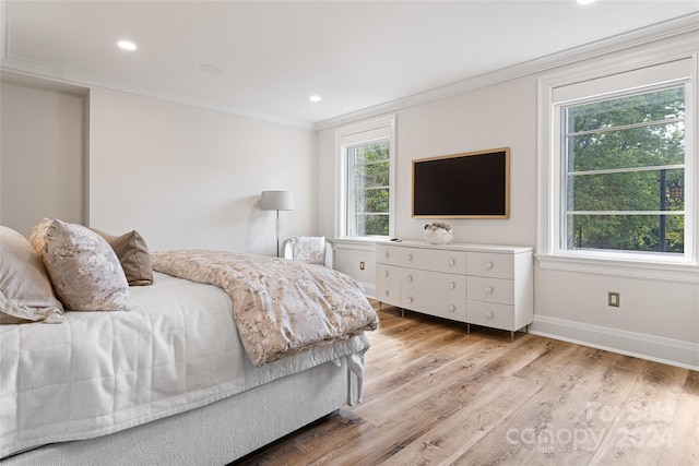 bedroom with ornamental molding and light hardwood / wood-style flooring