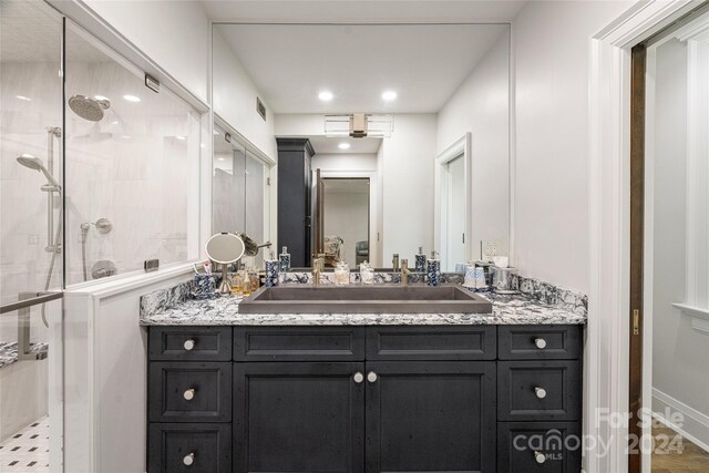 bathroom with vanity, wood-type flooring, and tiled shower