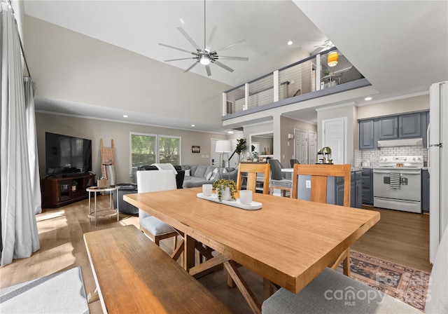 dining room with wood-type flooring, ceiling fan, and ornamental molding