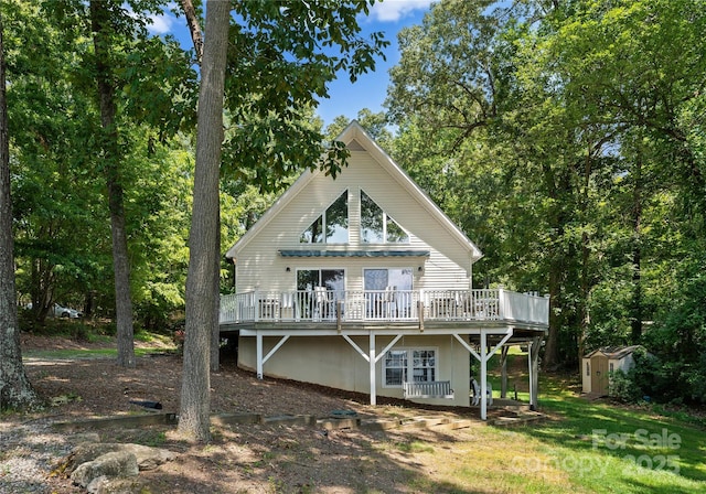 back of property with a wooden deck and a storage shed