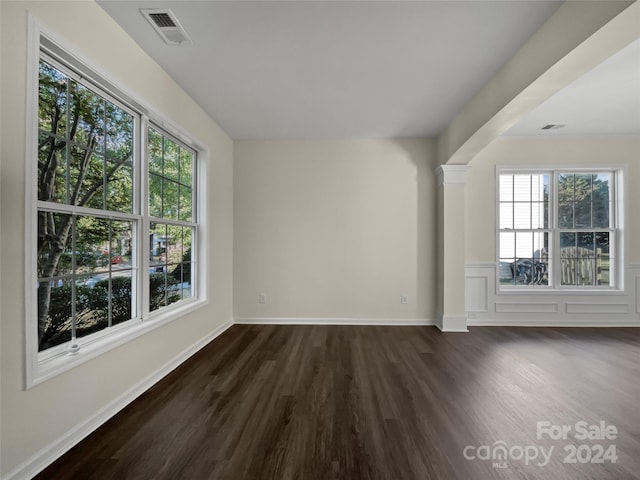 unfurnished room featuring baseboards, visible vents, and dark wood-type flooring