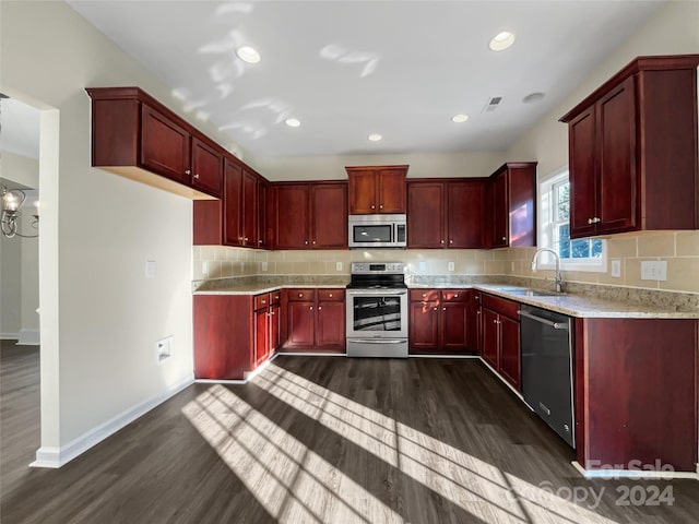 kitchen featuring dark brown cabinets, appliances with stainless steel finishes, dark wood-type flooring, and a sink