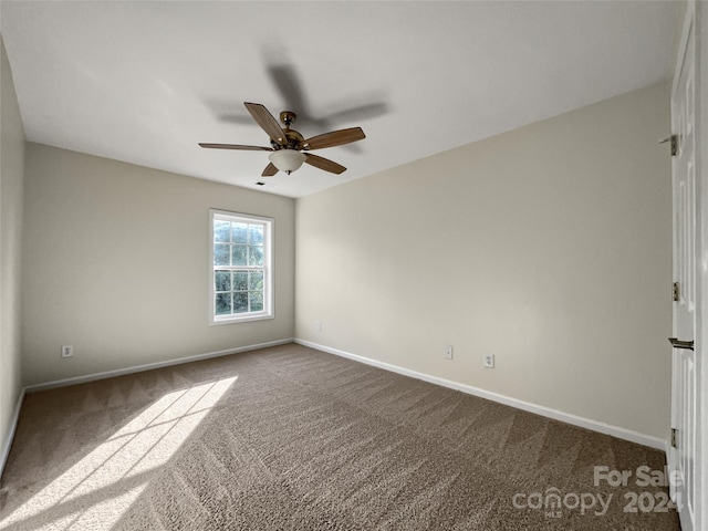 empty room with carpet, baseboards, and a ceiling fan