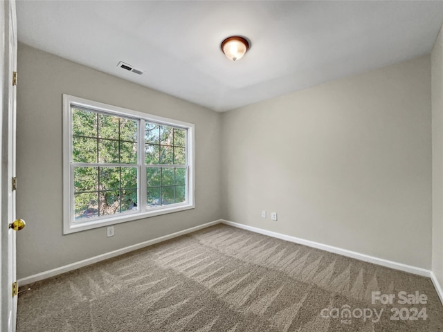 empty room featuring baseboards, visible vents, and carpet flooring