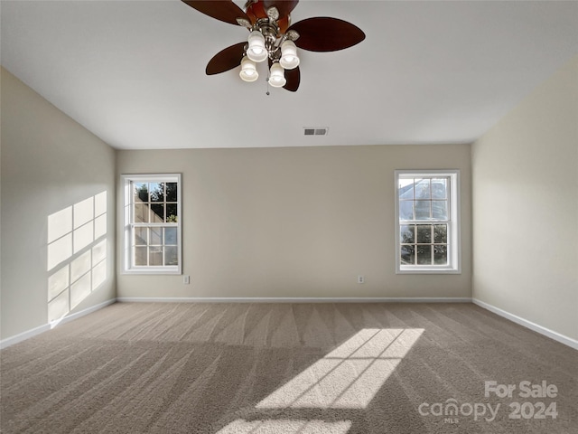 spare room with baseboards, visible vents, and light colored carpet