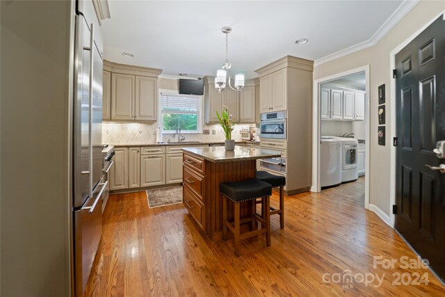 10235 Mount Holly Rd, Charlotte, NC 28214 - kitchen with hanging light fixtures, a kitchen breakfast bar, stainless steel appliances, a center island, and hardwood / wood-style floors