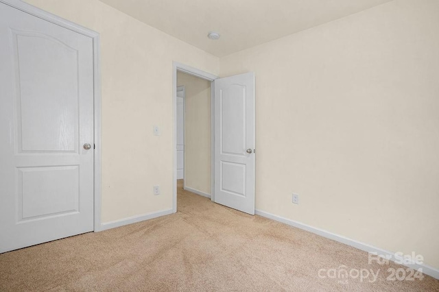 unfurnished bedroom featuring light carpet