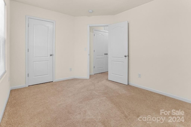 unfurnished bedroom featuring light carpet