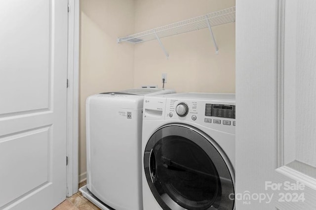 laundry area with washing machine and dryer and light tile patterned flooring