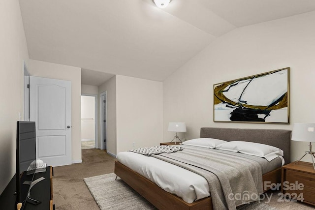 bedroom featuring light colored carpet and vaulted ceiling