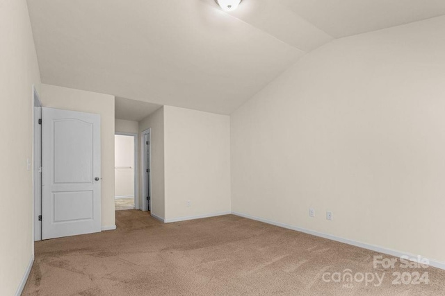 interior space featuring lofted ceiling and light carpet