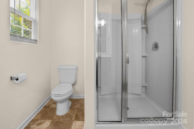 bathroom with toilet, tile patterned flooring, and a shower with door