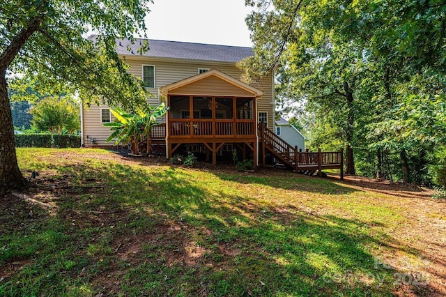 rear view of property featuring a sunroom and a lawn