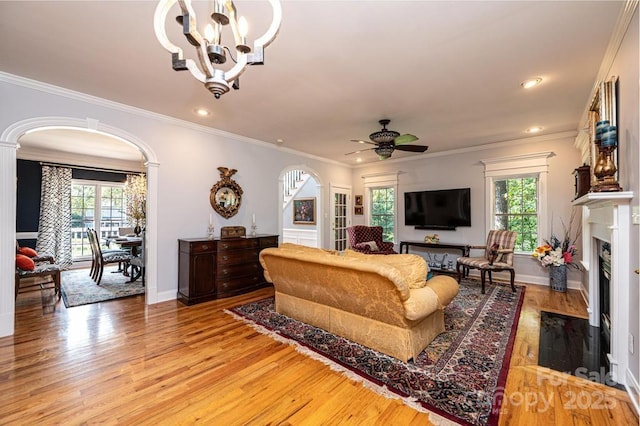 living room featuring arched walkways, plenty of natural light, and a fireplace with flush hearth