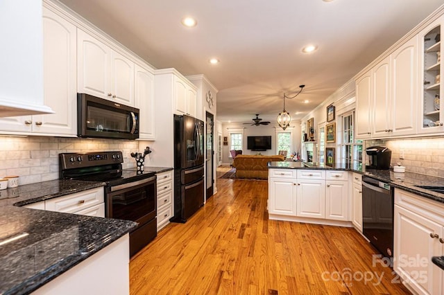 kitchen with white cabinetry, light wood finished floors, black appliances, and a peninsula