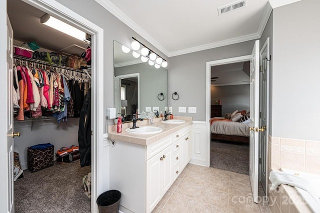 bathroom featuring double vanity, crown molding, visible vents, and a sink