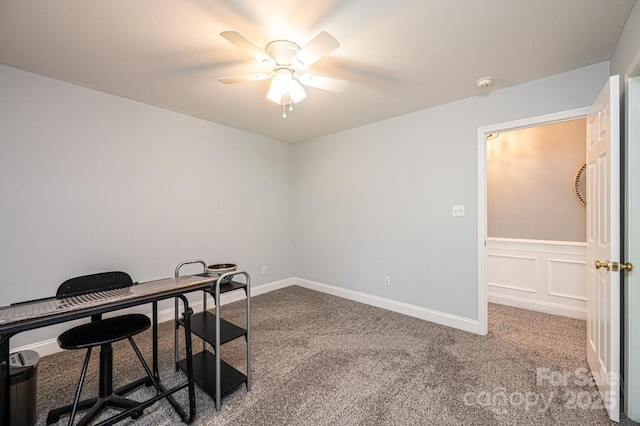 office space featuring ceiling fan, carpet, baseboards, and a decorative wall