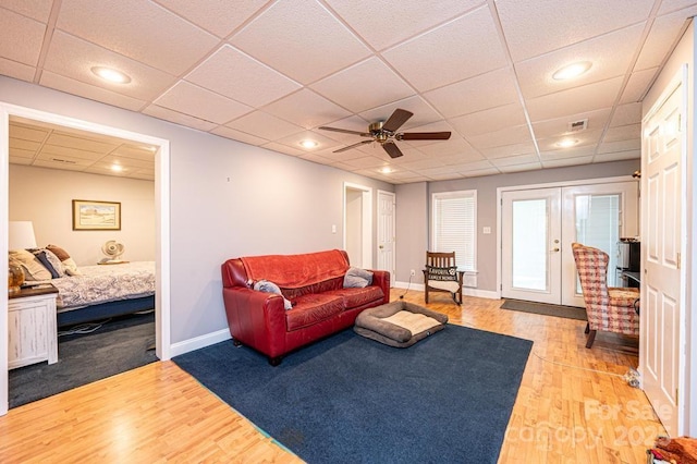 living room with light wood finished floors, baseboards, visible vents, ceiling fan, and french doors