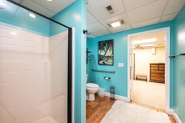 full bath featuring toilet, a stall shower, wood finished floors, and visible vents