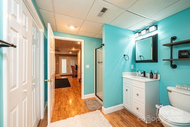 bathroom featuring a stall shower, visible vents, vanity, and wood finished floors