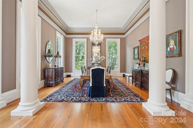 dining room with ornamental molding, light wood-type flooring, a chandelier, and ornate columns