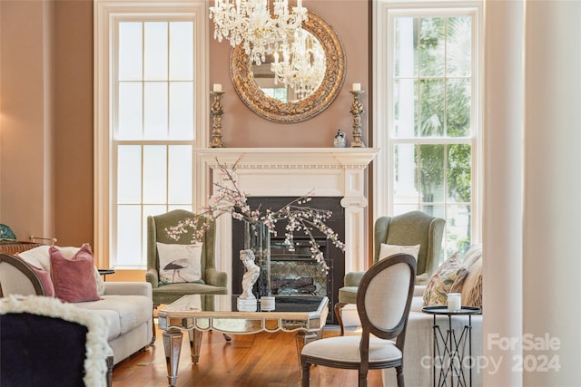 living area featuring wood-type flooring, a fireplace, and a chandelier